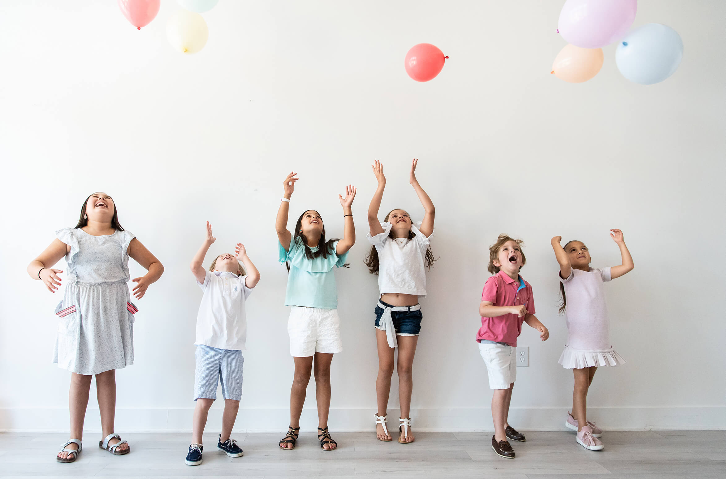 several kids playing with balloons