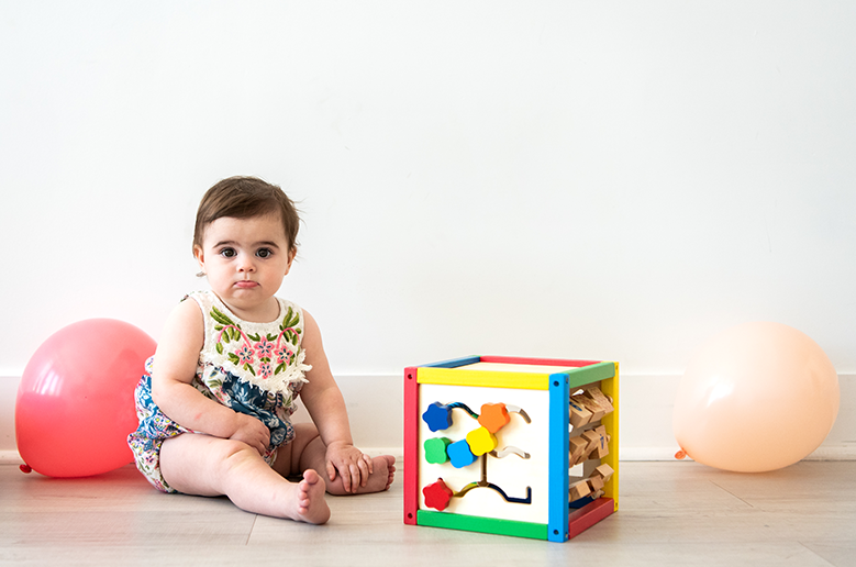 baby next to balloons